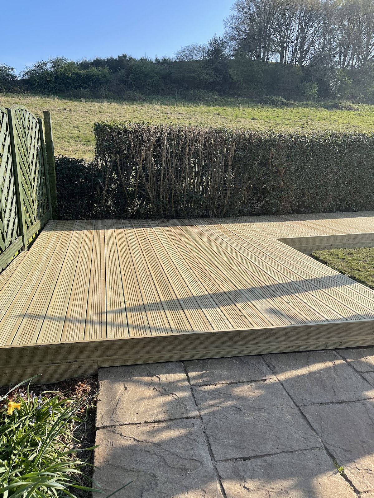 A large timber deck with a countryside backdrop