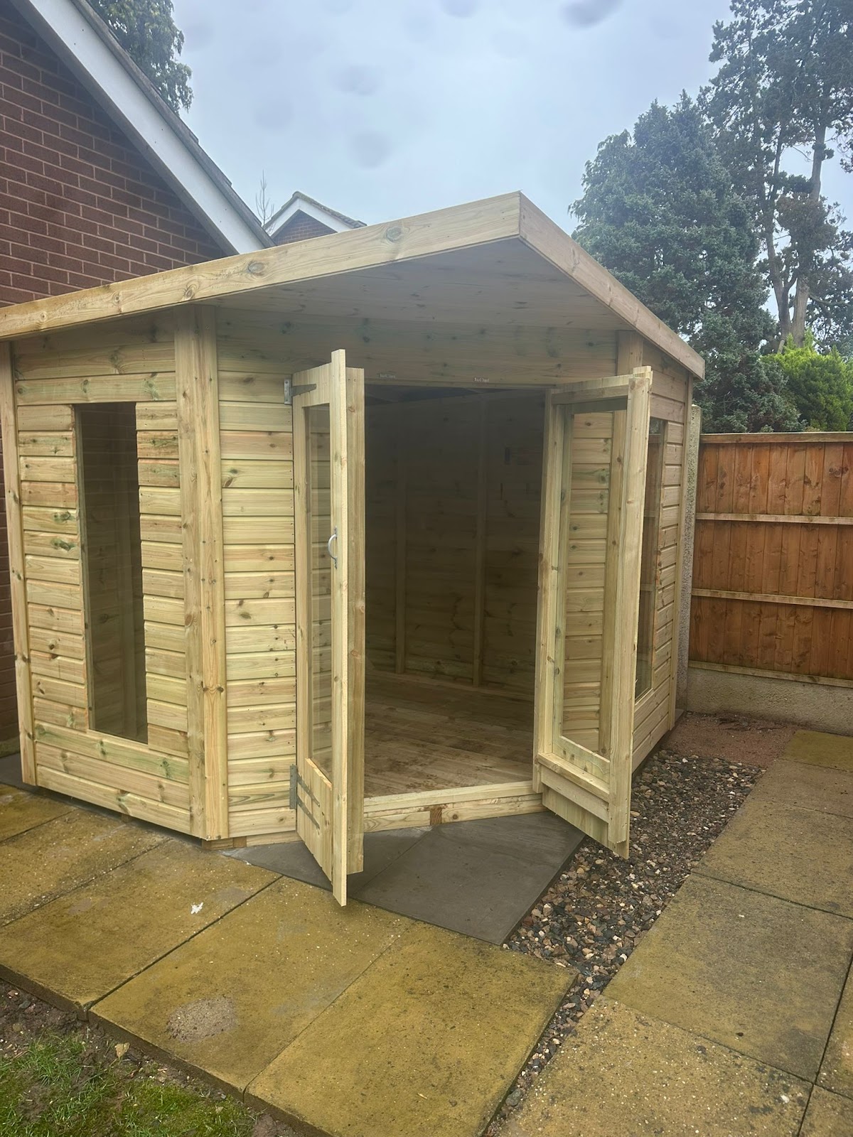 A corner summerhouse with its double doors open