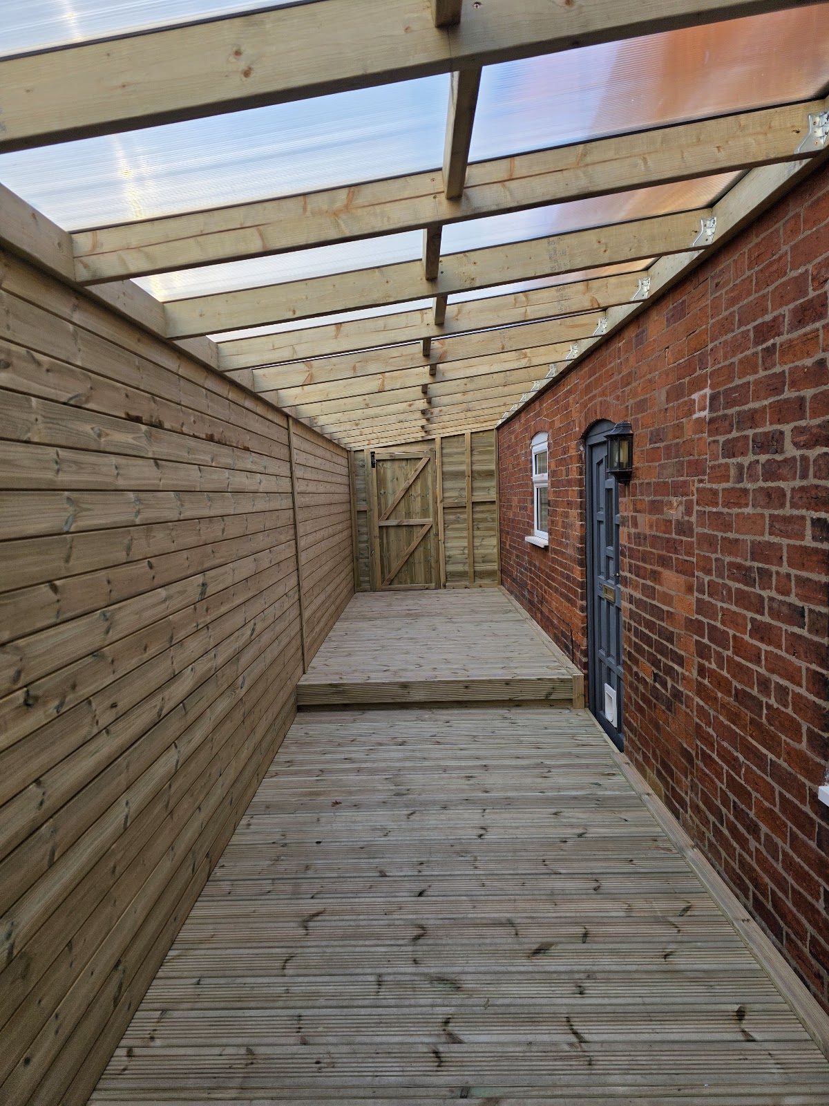 A covered decked side passage with a clear roof